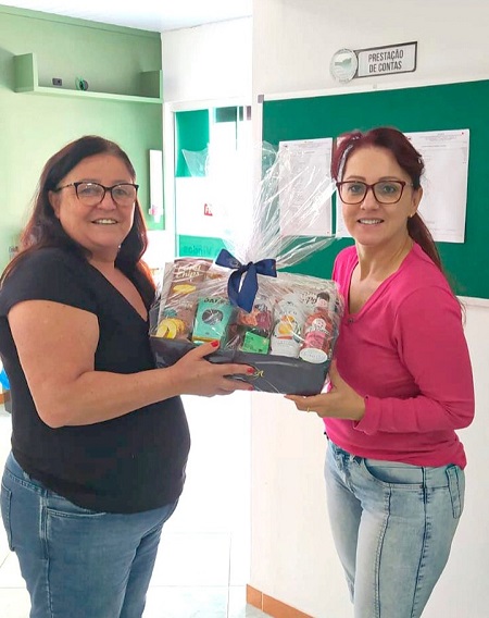 A sócia sorteada na promoção de Dia das Mães do SINSEB, Evandra Cândido, recebeu uma das cestas das mãos da presidente do SINSEB, Tânia Mara Vieir...