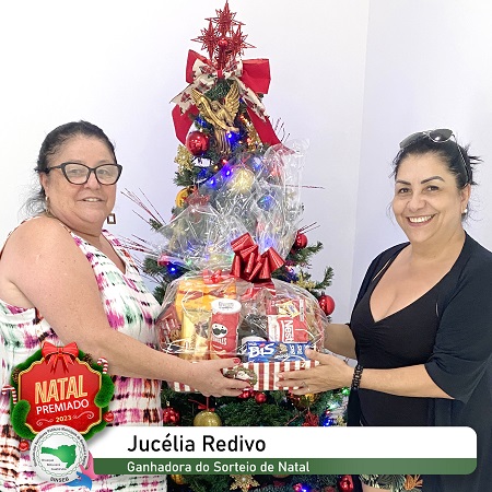 A sócia sorteada na premiação de Natal do SINSEB, Jucélia Redivo, recebendo sua cesta de Natal.
